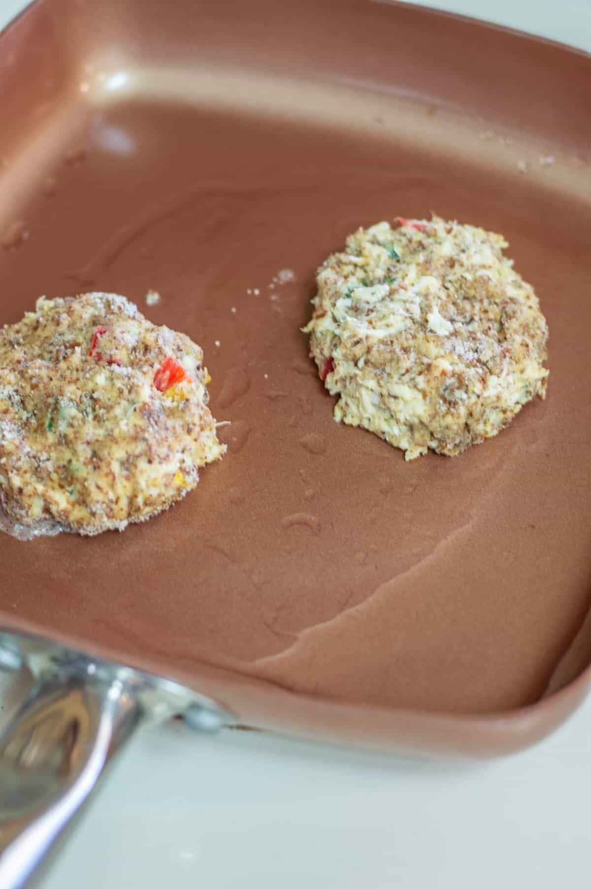 Whole30 crab cakes being fried in a pan