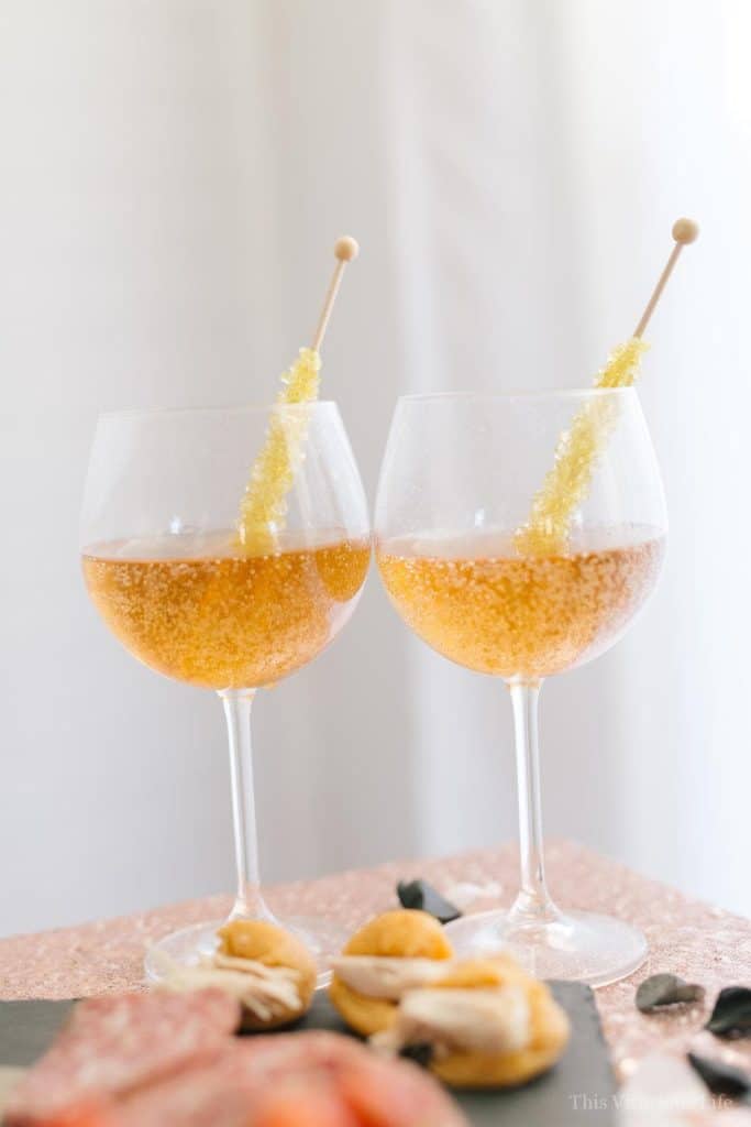 Sparkling cider in wine glasses with rock candy suckers