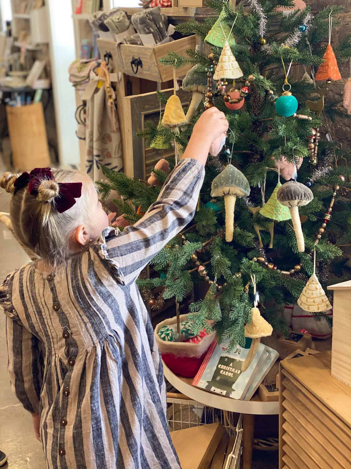 Little girl decorating modern Christmas tree