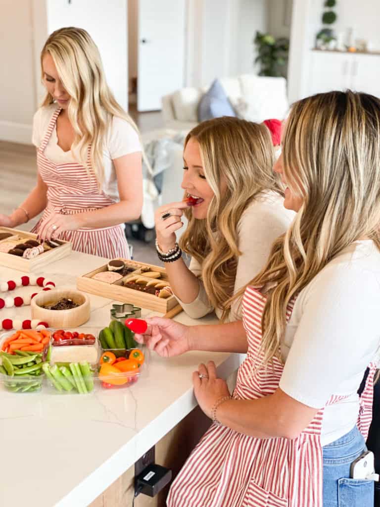 Girls eating veggie tray around a counter