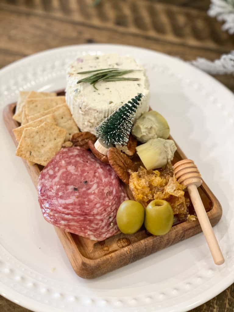 Individual charcuterie board on a wood slab on a white plate