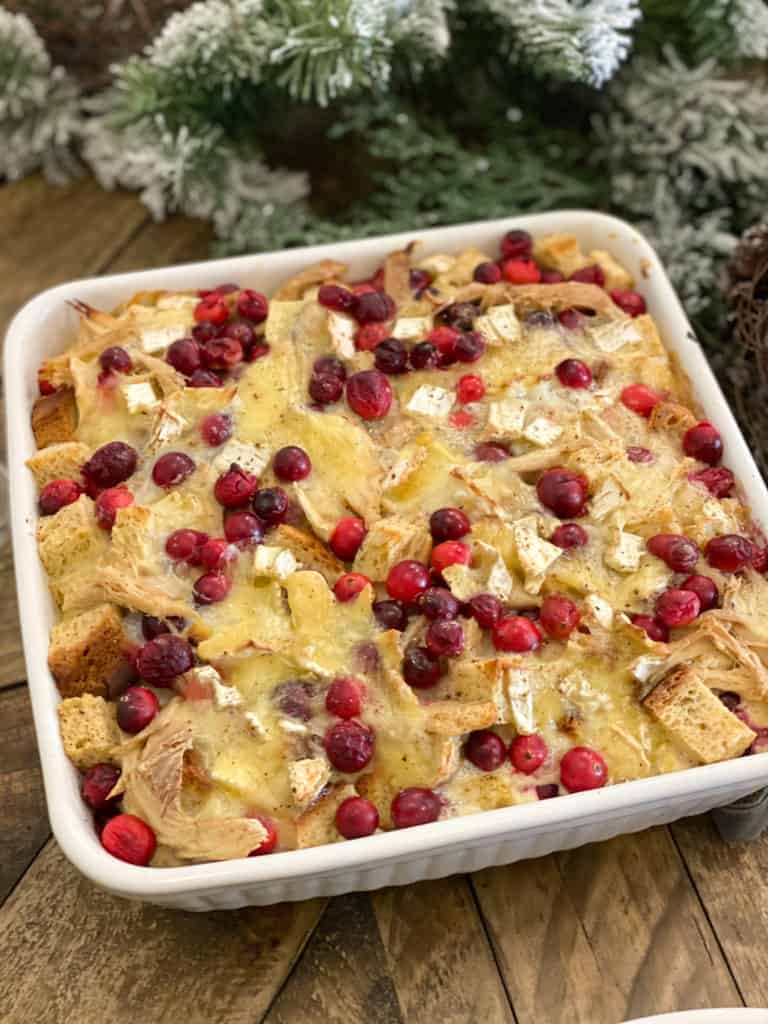 Savory cranberry, turkey and brie bread pudding in a white dish