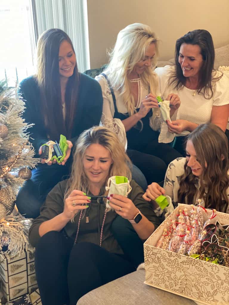 Five ladies smiling opening gifts