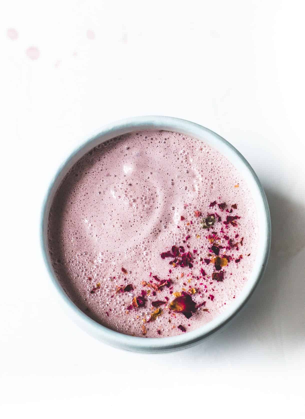 Pink moon milk in a cup with rose petals