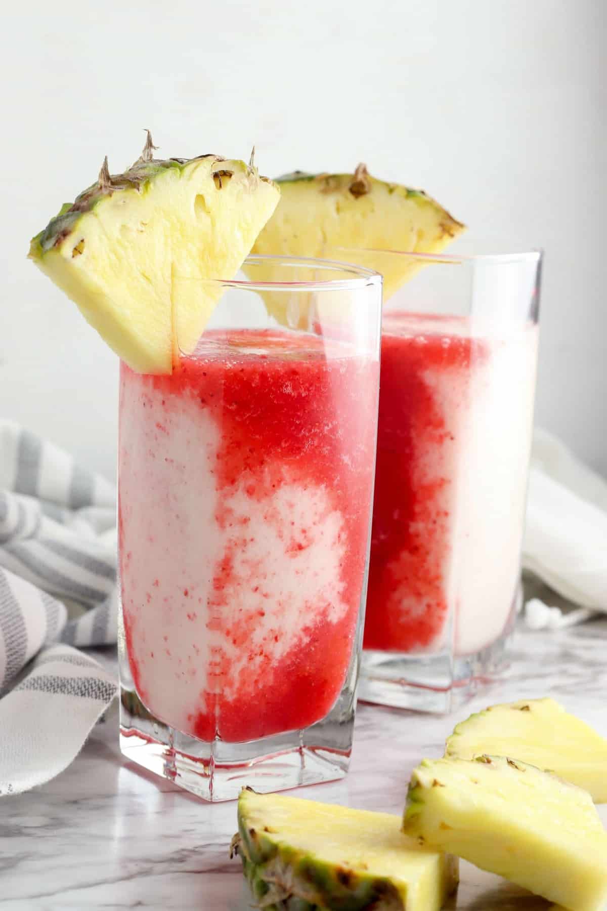 Strawberry pina colada mocktail with sliced pineapple