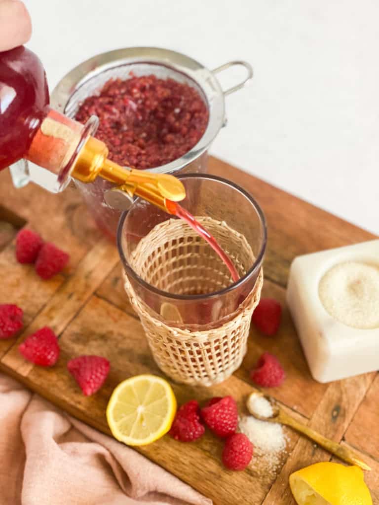 Raspberry Simple Syrup being poured into a glass