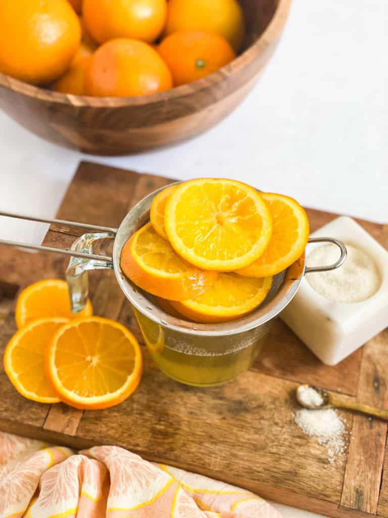 Orange Simple Syrup fruit segments in a strainer