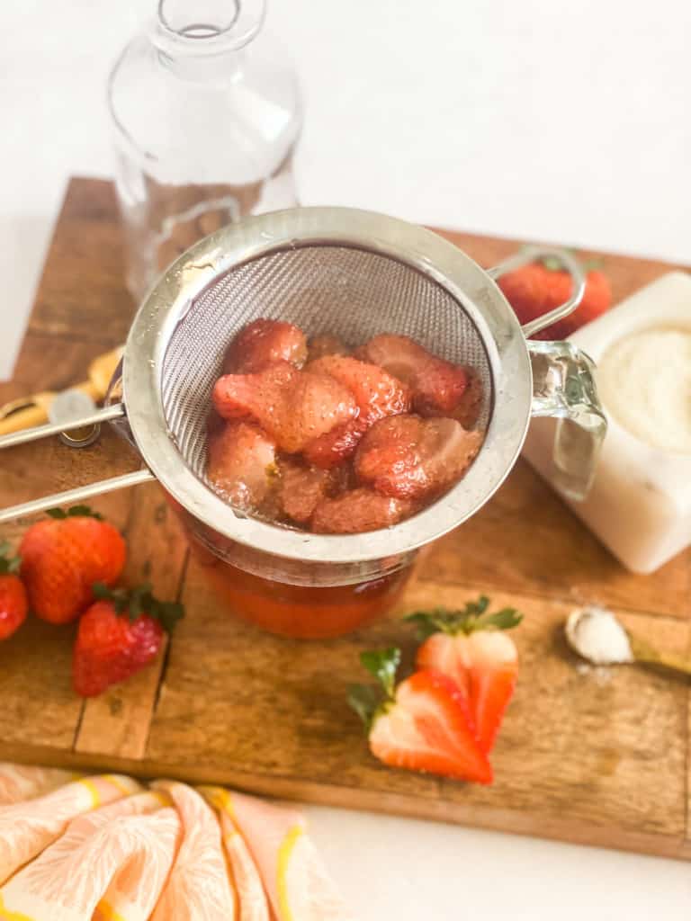 Strawberry Simple Syrup fruit segments in a strainer