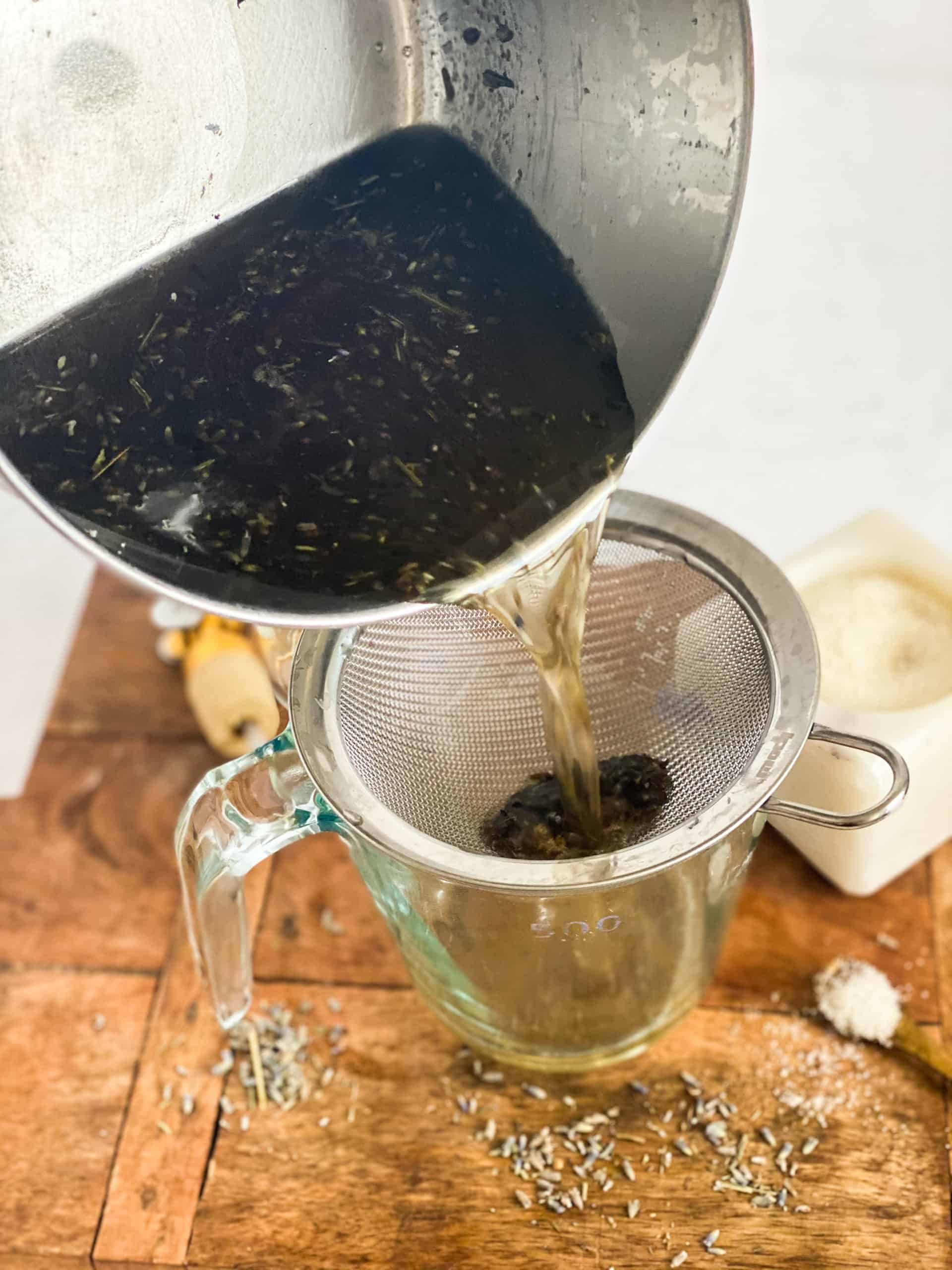 Lavender Simple Syrup being poured into a strainer
