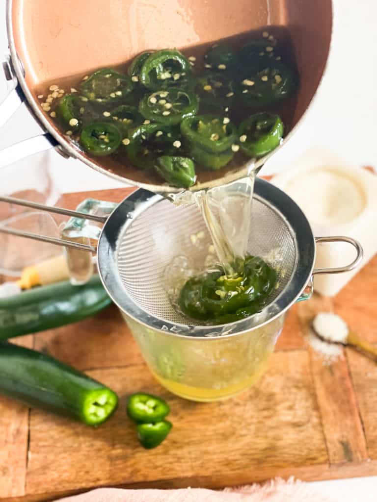 Jalapeño Simple Syrup being poured into a strainer