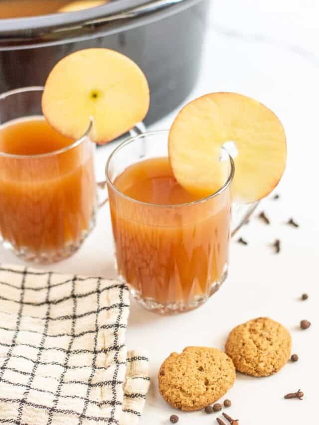 Crockpot apple cider in glasses with apple slices