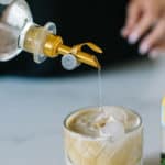 White Russian Mocktail with simple syrup being poured