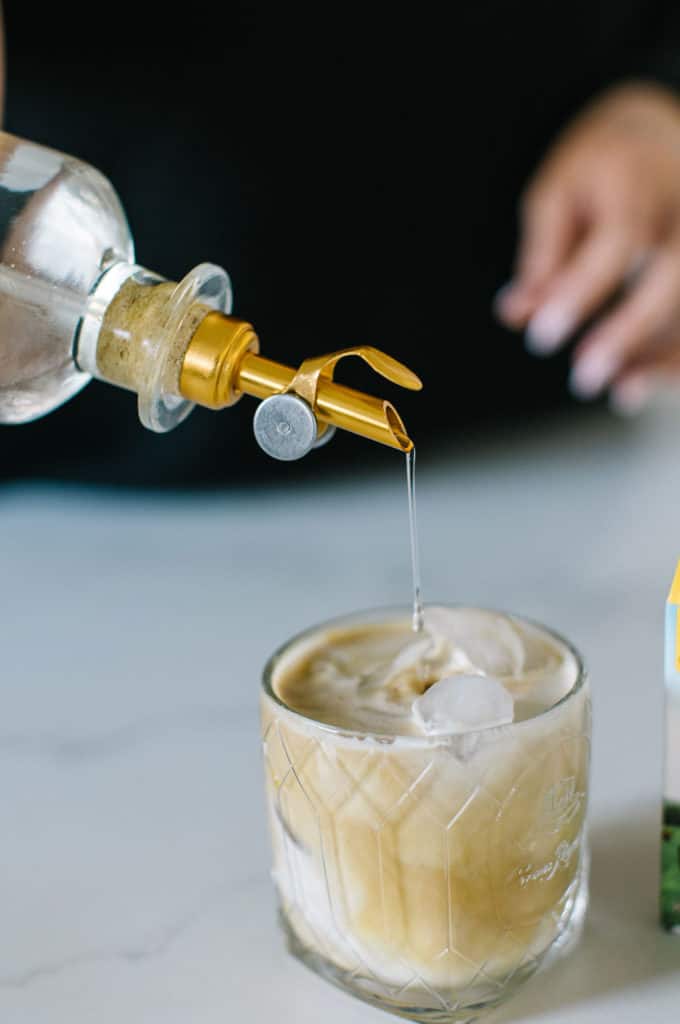 White Russian Mocktail with simple syrup being poured