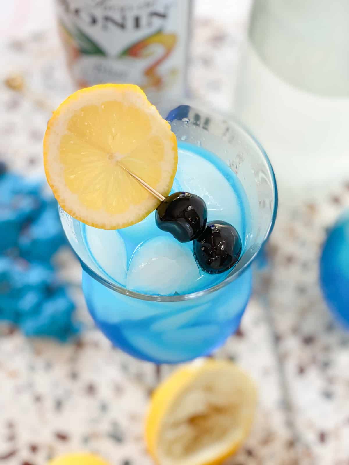 Blue lagoon mocktail in a glass with lemon