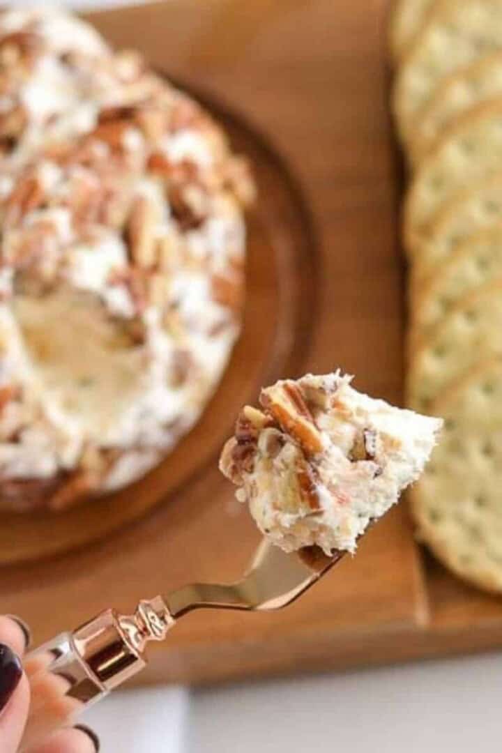 BEST Cheeseball Ever on a serving spoon in hand
