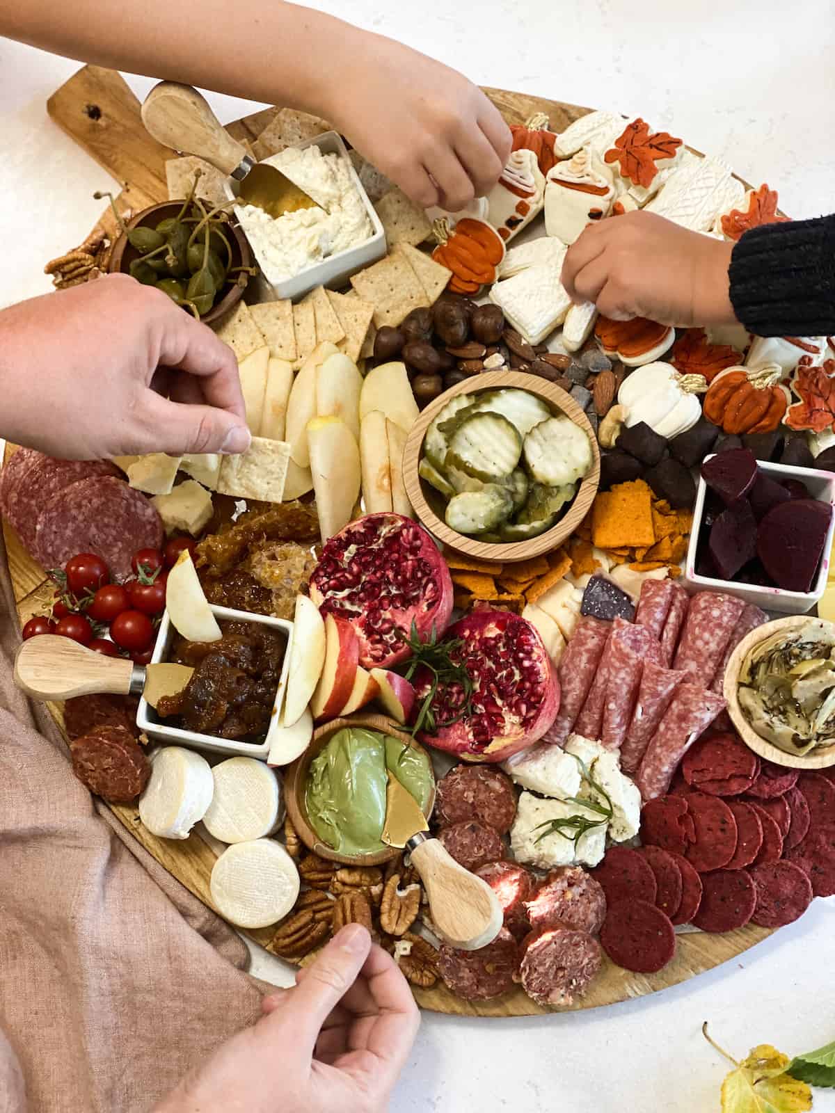 Hands eating Thanksgiving charcuterie board