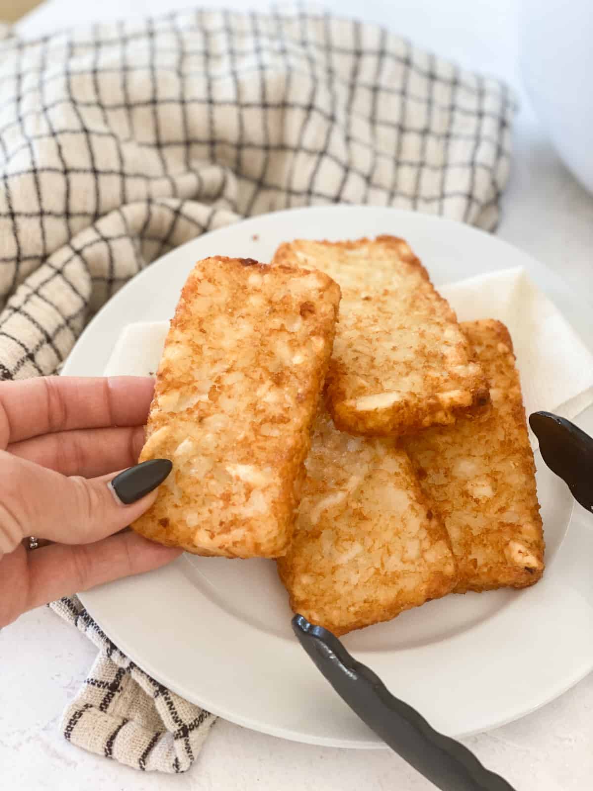 Hash Browns in Air Fryer hand holding patty