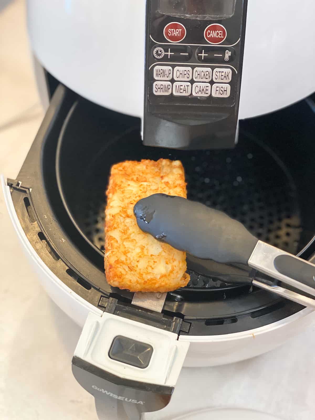 Hash Browns in Air Fryer tongs getting it out