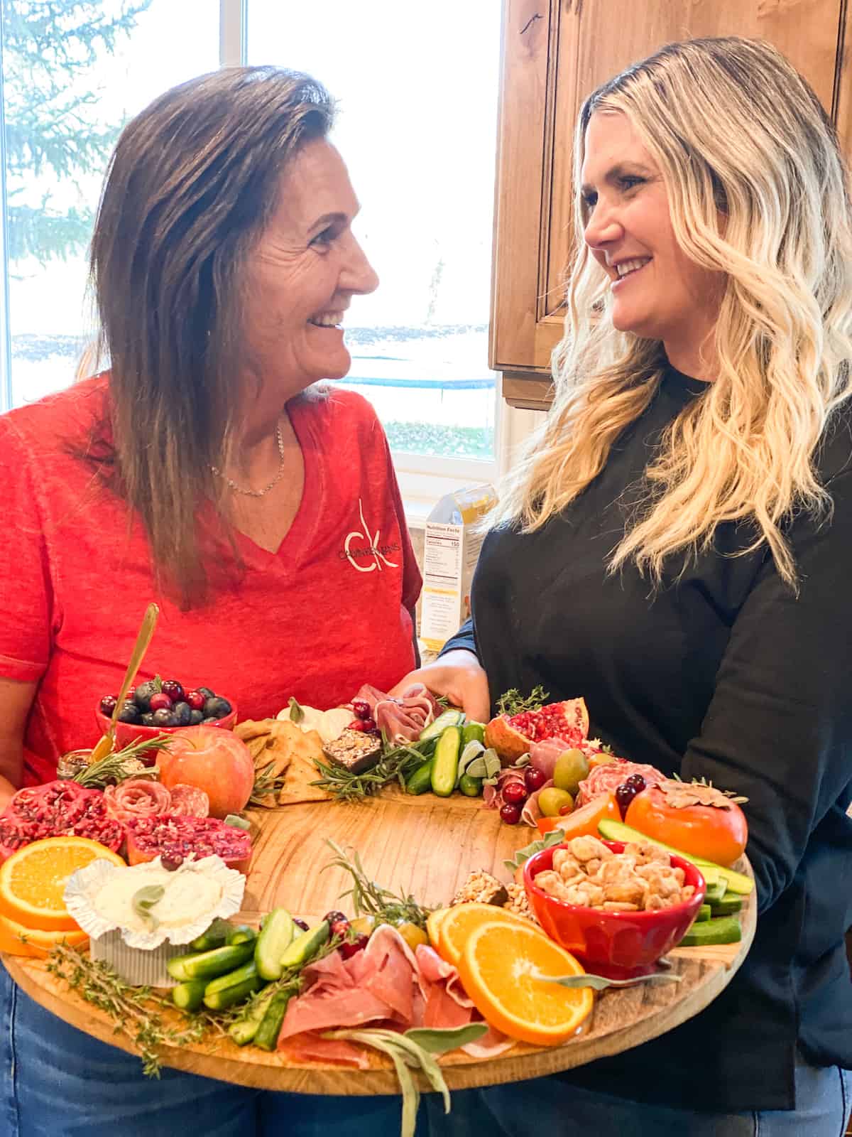Mom and daughter holding large Christmas charcuterie board