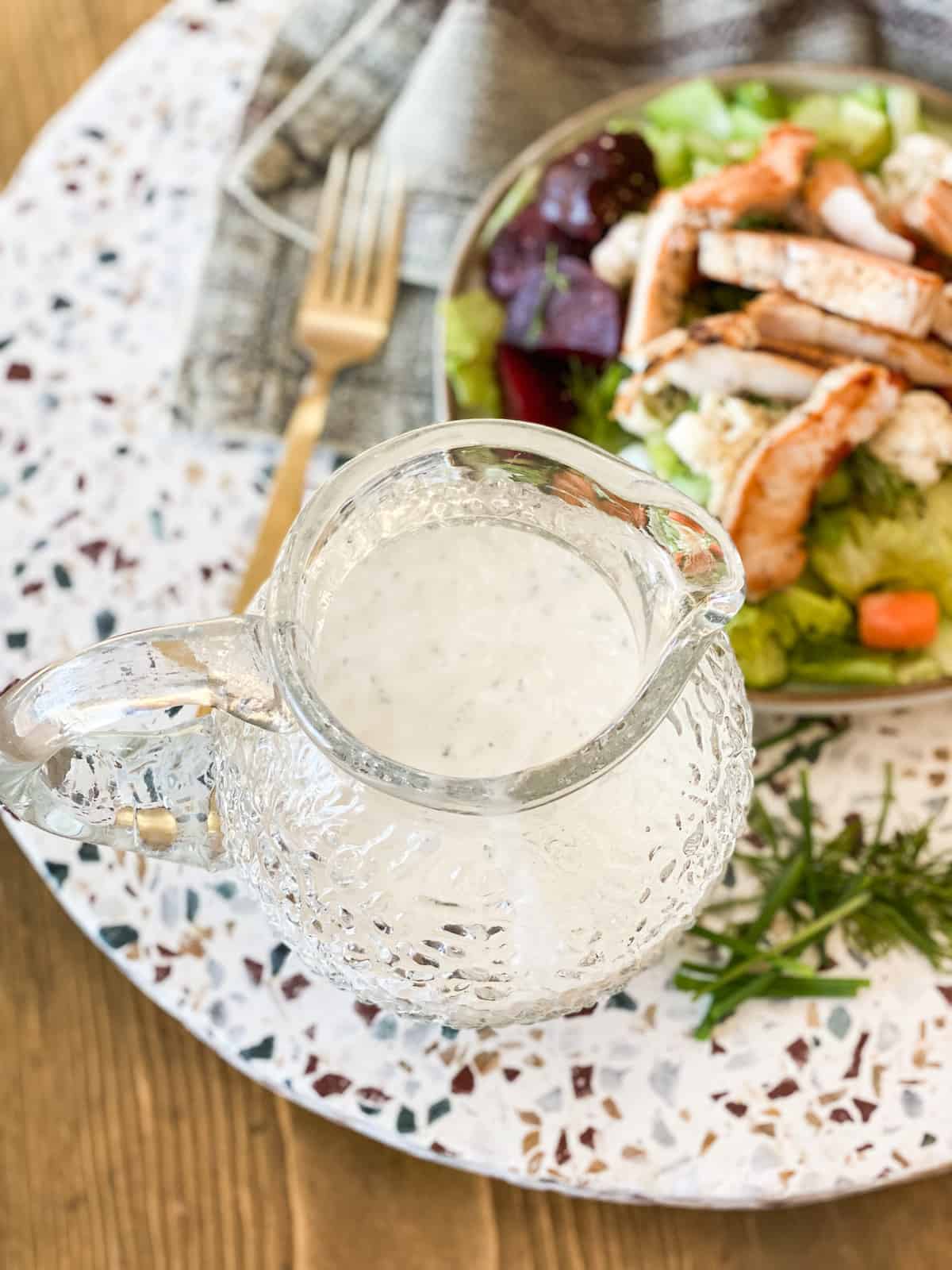 Whole30 Ranch Dressing by a salad in a glass jar