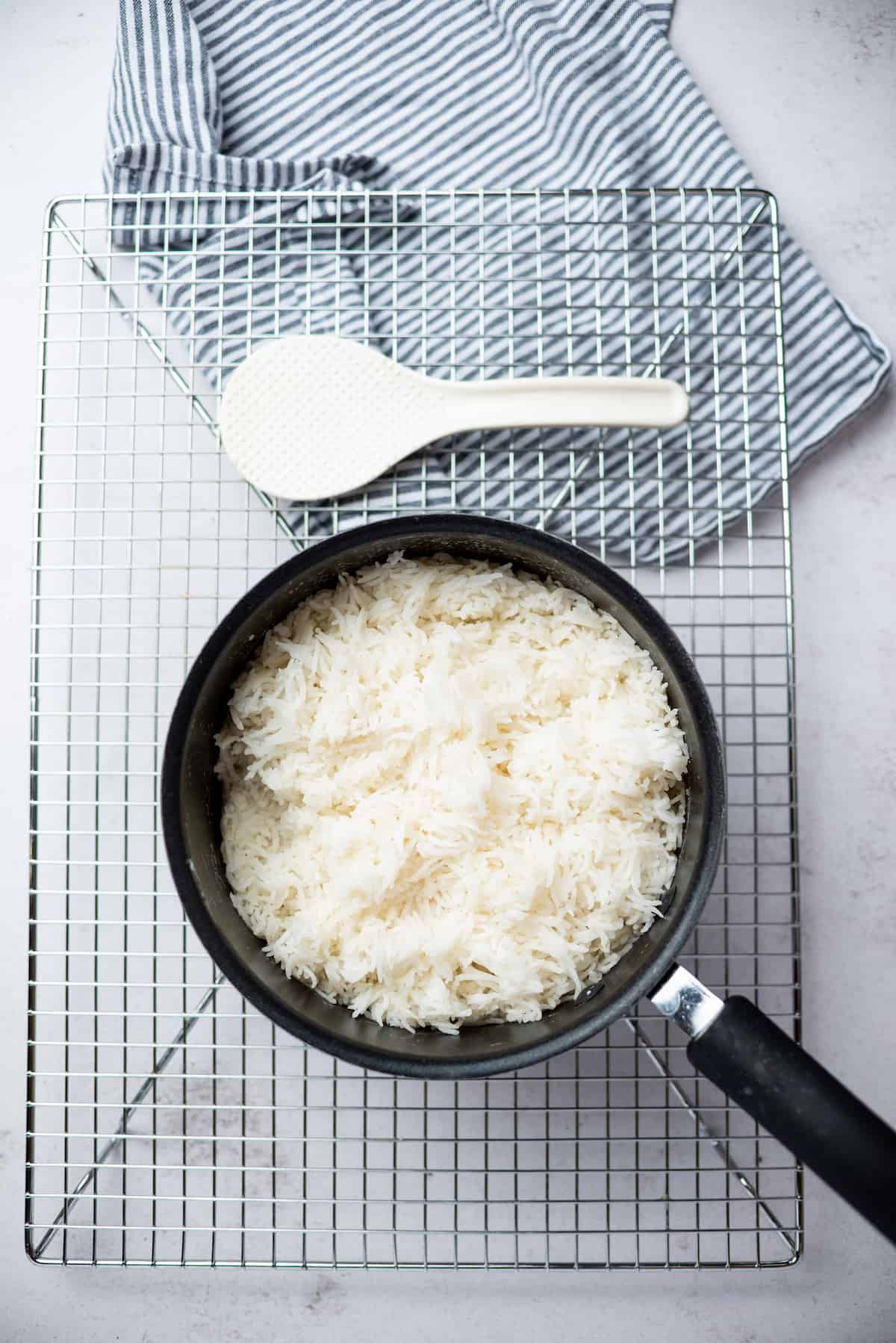 White rice in a pot with white spoon