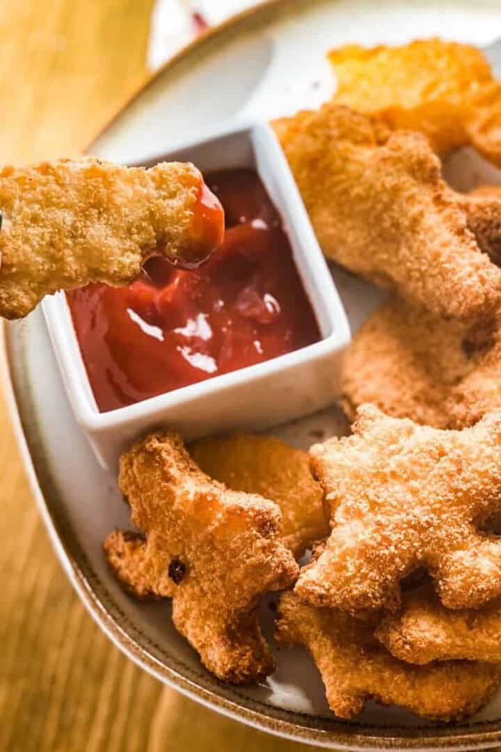 Dino nuggets air fryer recipe being dipped in ketchup