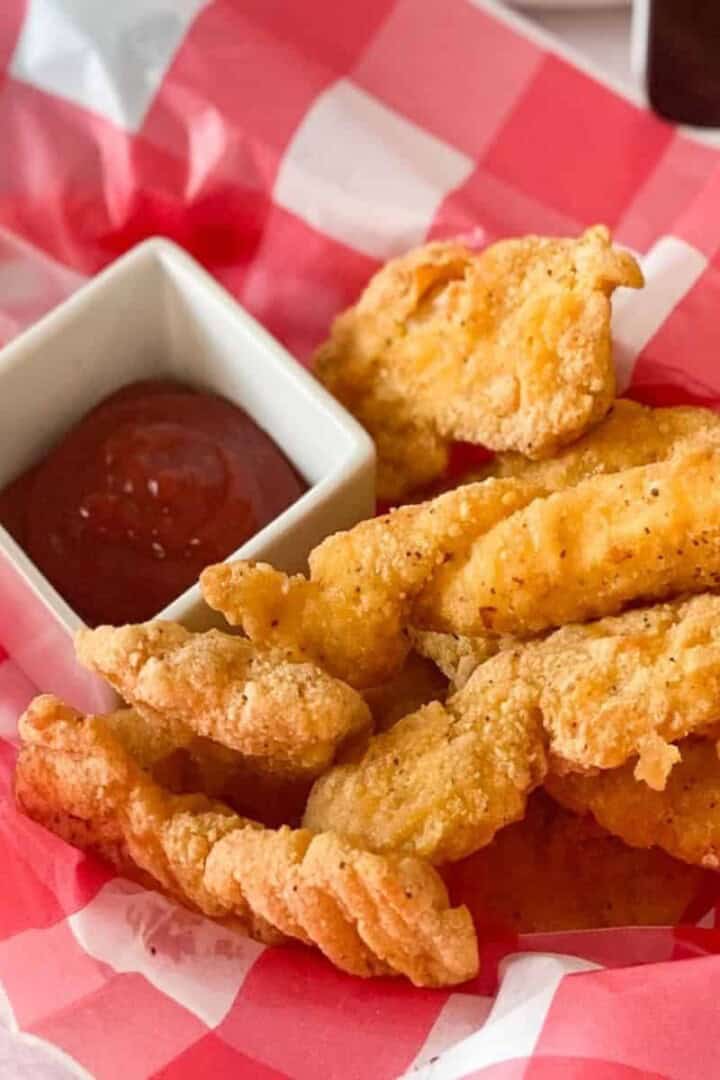 Frozen Chicken Tenders in Air Fryer cooked in a checkered basket