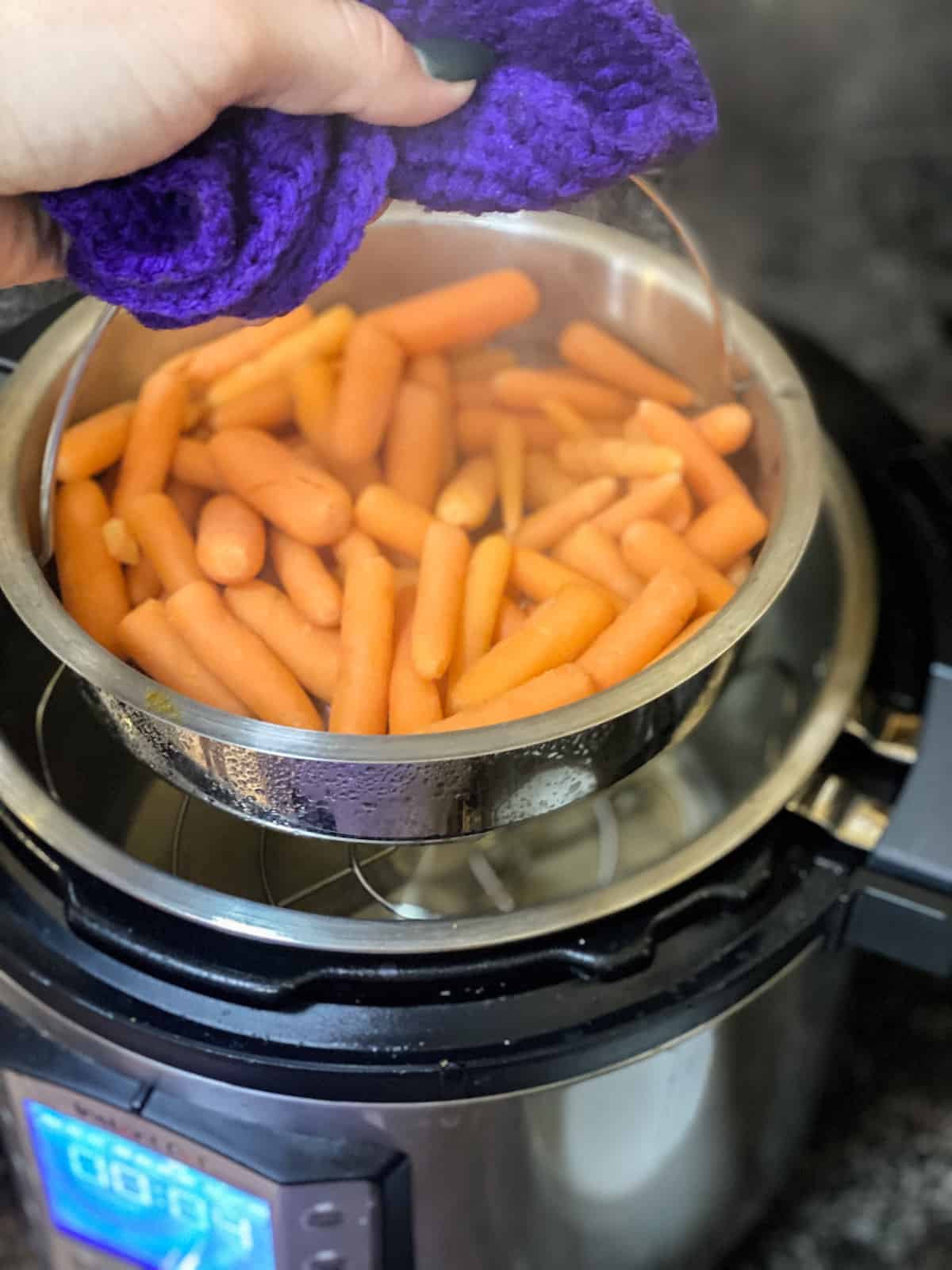 Steamed instant pot carrots being pulled out