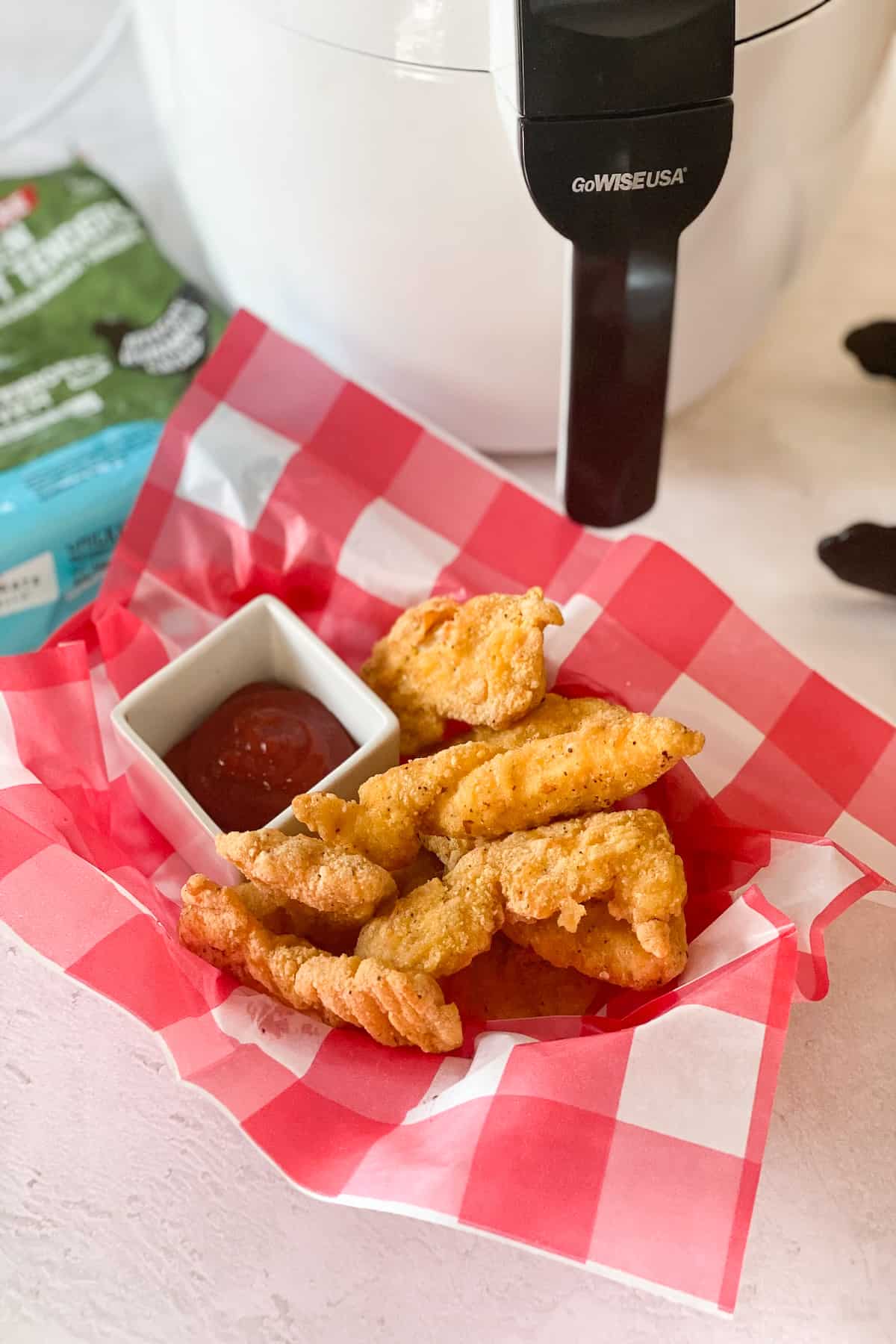 Frozen Chicken Tenders in Air Fryer cooked and plated in a checkered basket