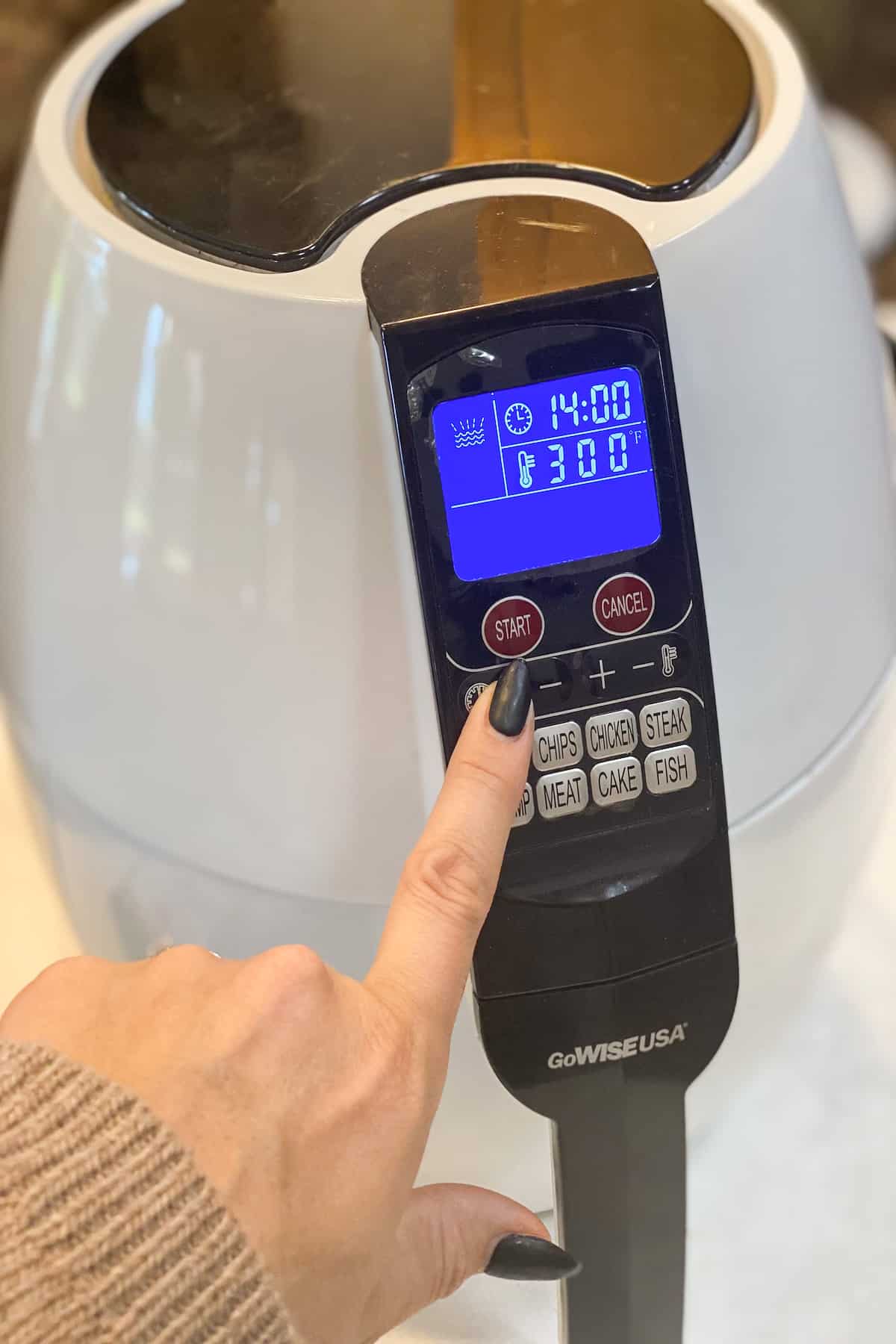 Frozen Chicken Tenders in Air Fryer cooking with hand on air fryer