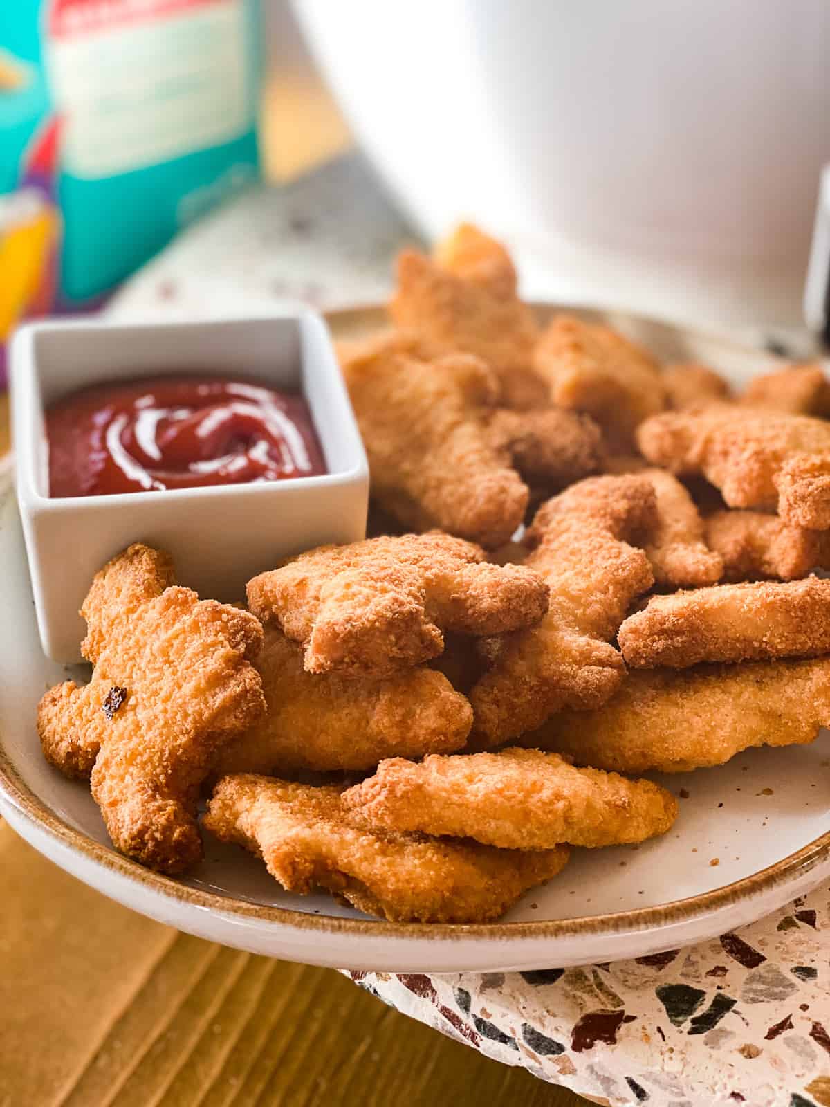 Dino nuggets air fryer style on a plate with ketchup