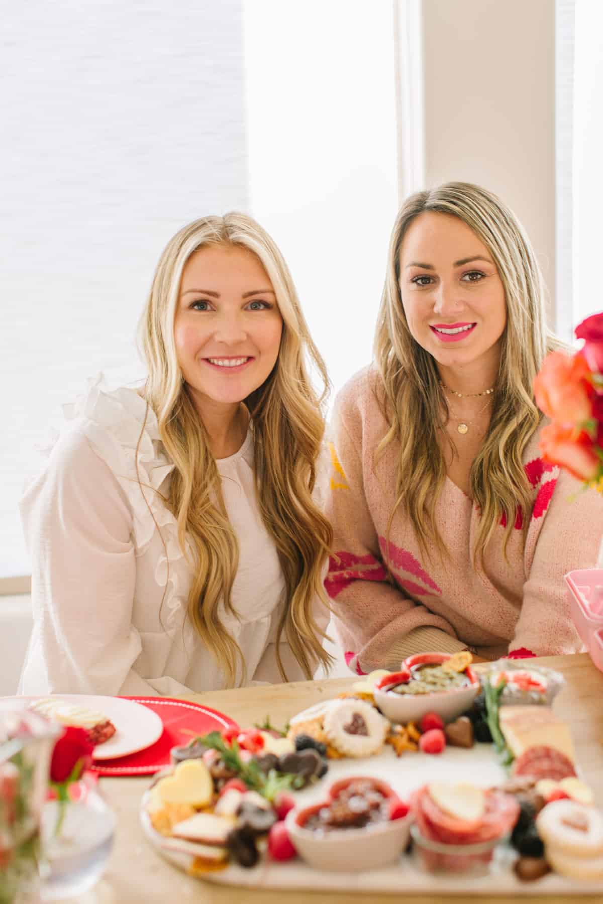 Two girls smiling with a Valentines charcuterie