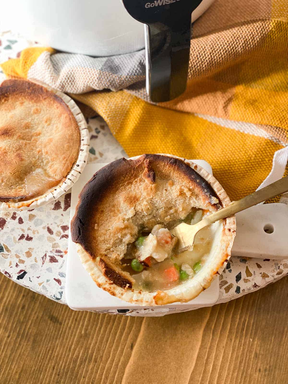 Make a delicious pot pie in air fryer in under 16 minutes! A golden brown pot pie is the perfect comfort food with creamy sauce and vegetables surrounded by crispy pie crust.