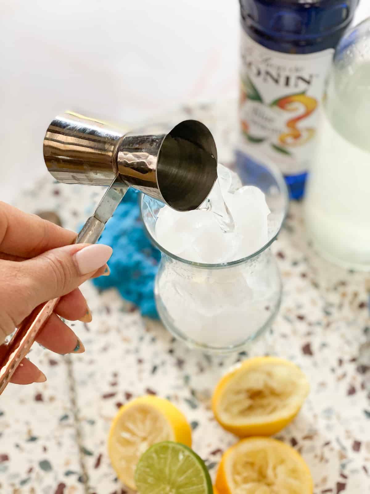 What is a mocktail? Hand pouring drink ingredient into a cup.