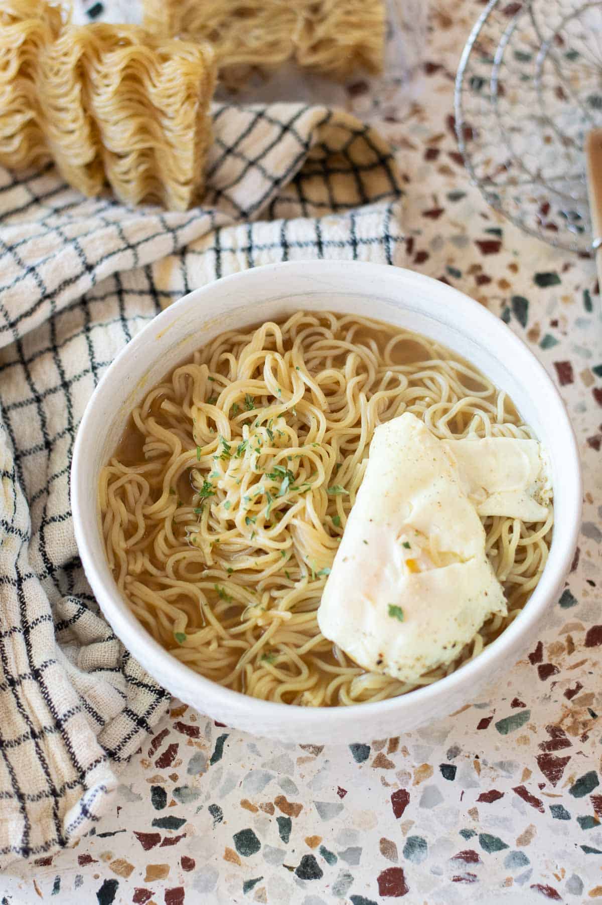 easy gluten free ramen in a white bowl topped with egg and spices