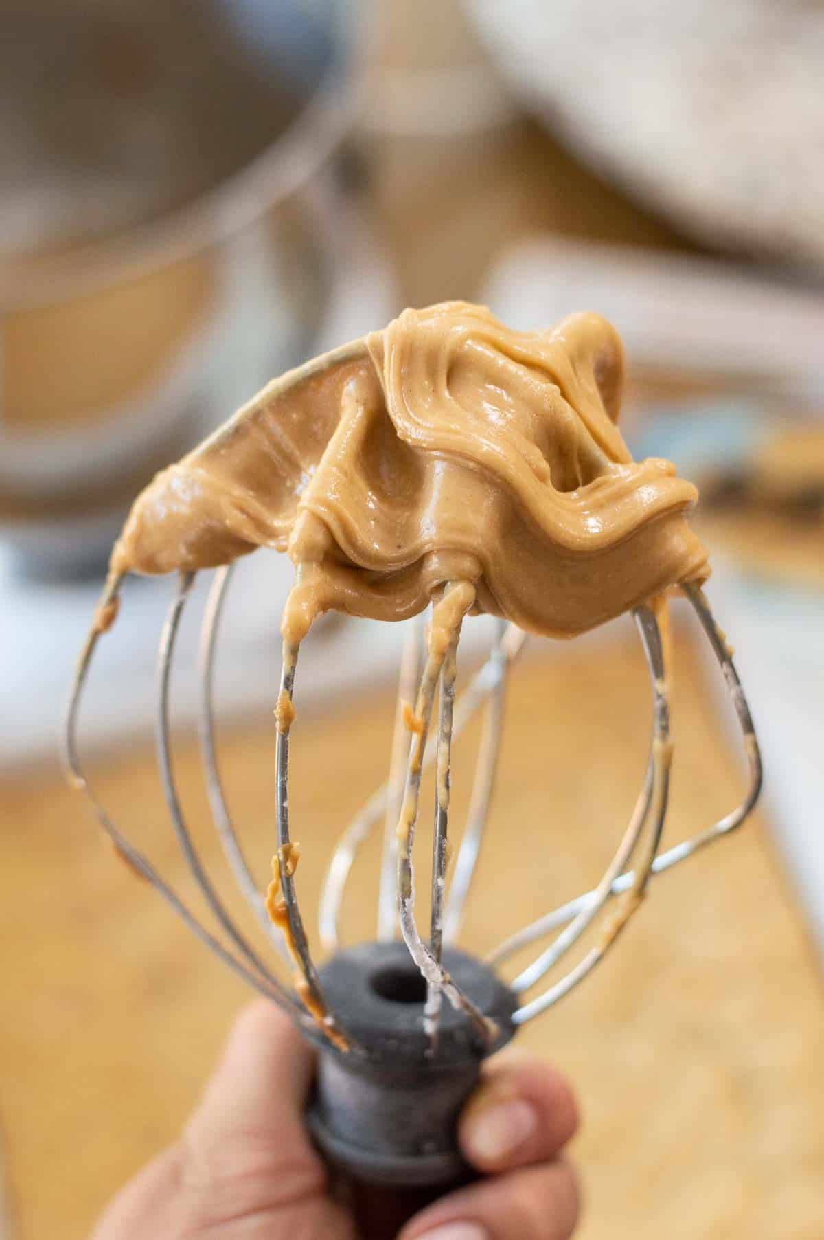 peanut butter frosting on a wire whisk