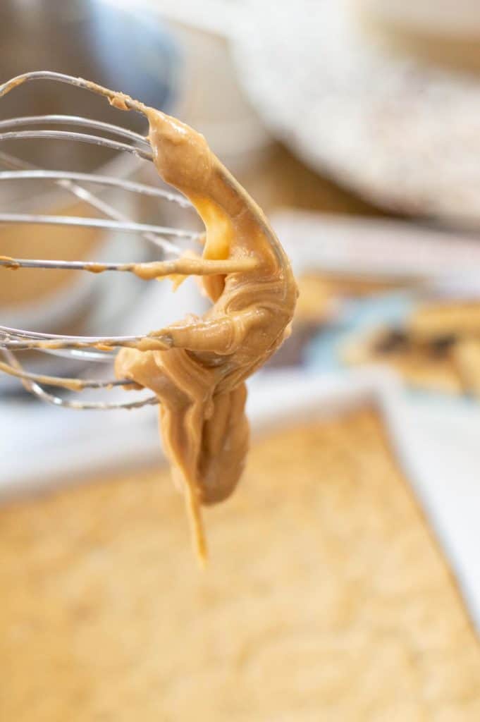 peanut butter frosting on a wire whisk