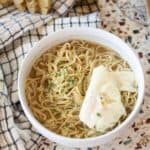 gluten free ramen in a white bowl with egg on top and seasoning