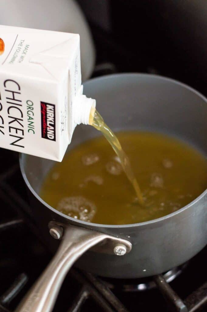 gluten free ramen step by step instructions chicken broth being poured into a pot