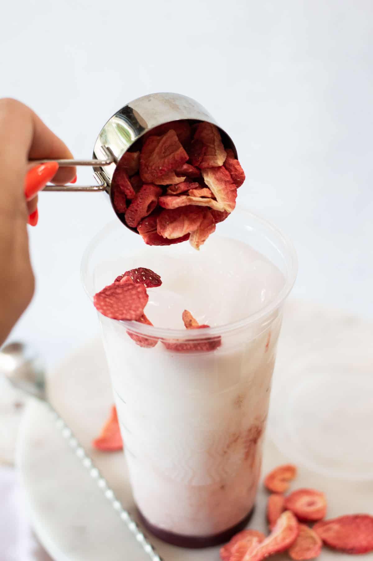 Starbucks Pink Drink Copycat in a plastic cup with dried strawberries