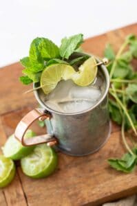 ginger beer mocktail tin cup with limes and mint
