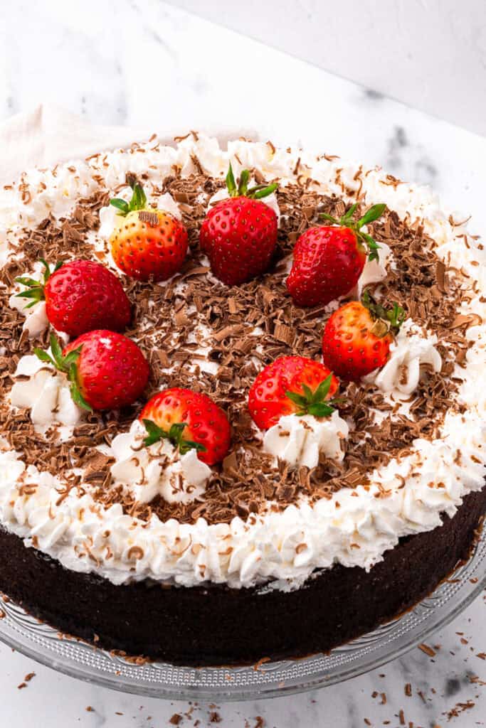 top down view of a circle Gluten Free Banana Black Bottom Pie with whipped cream, chocolate shavings, and strawberries on top