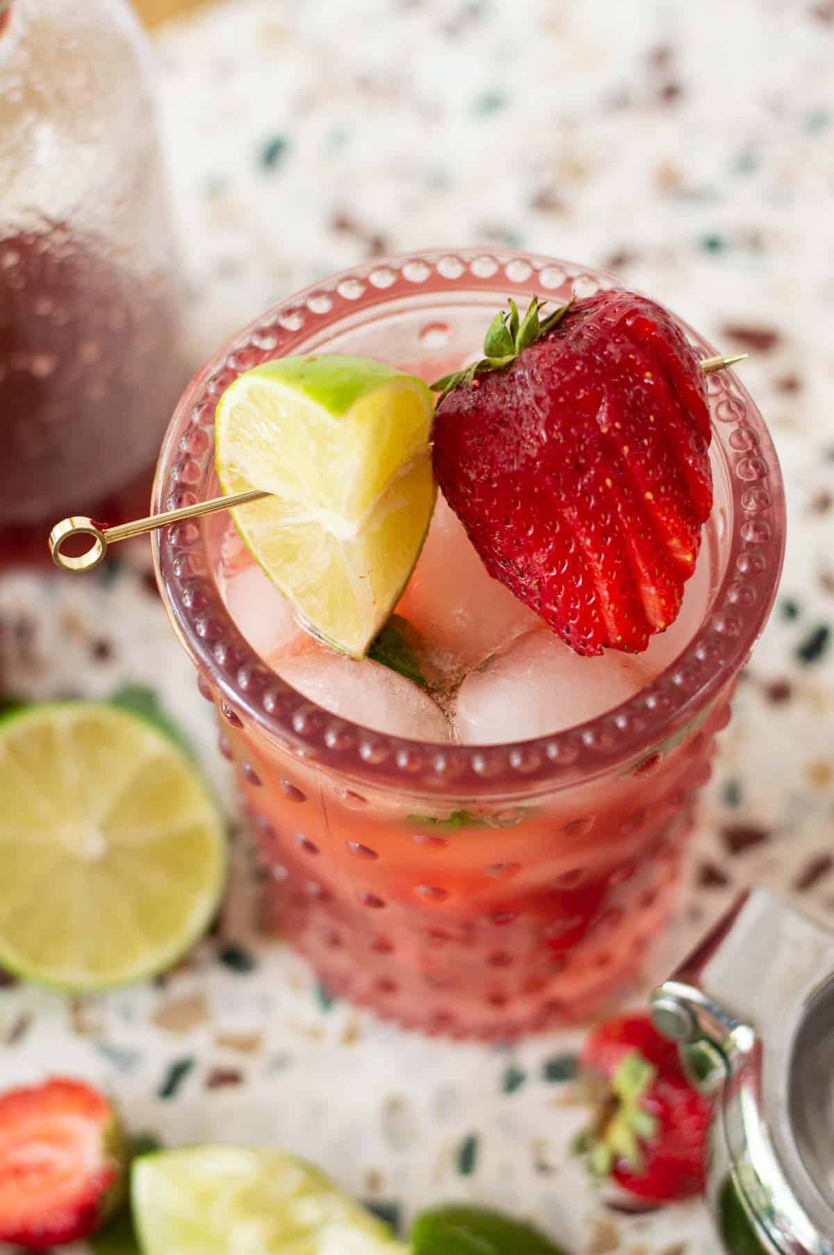 Strawberry Mojito Mocktail with lime and strawberries on a gold pick