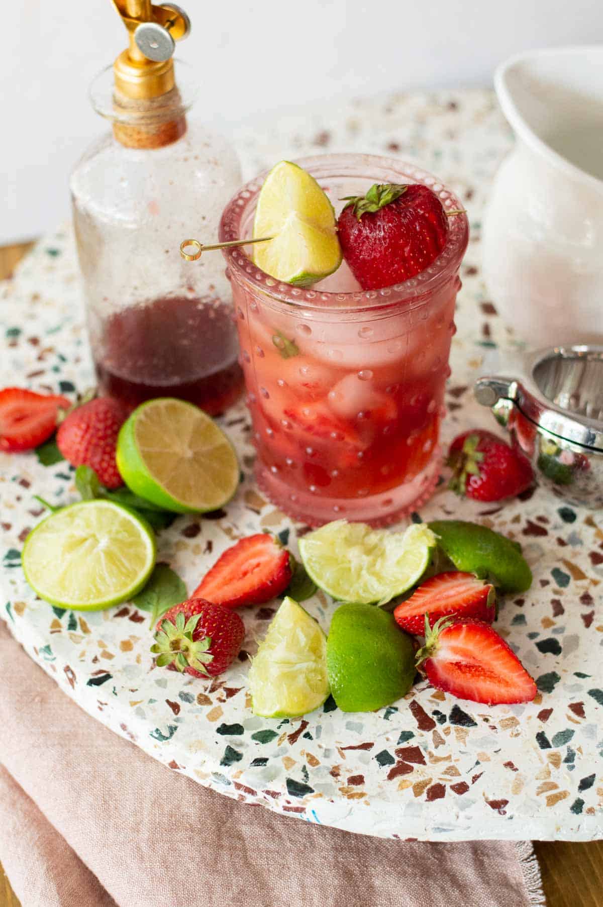 Strawberry Mojito Mocktail with limes and strawberries on a plate