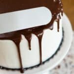 White frosted drip cake with chocolate ganache