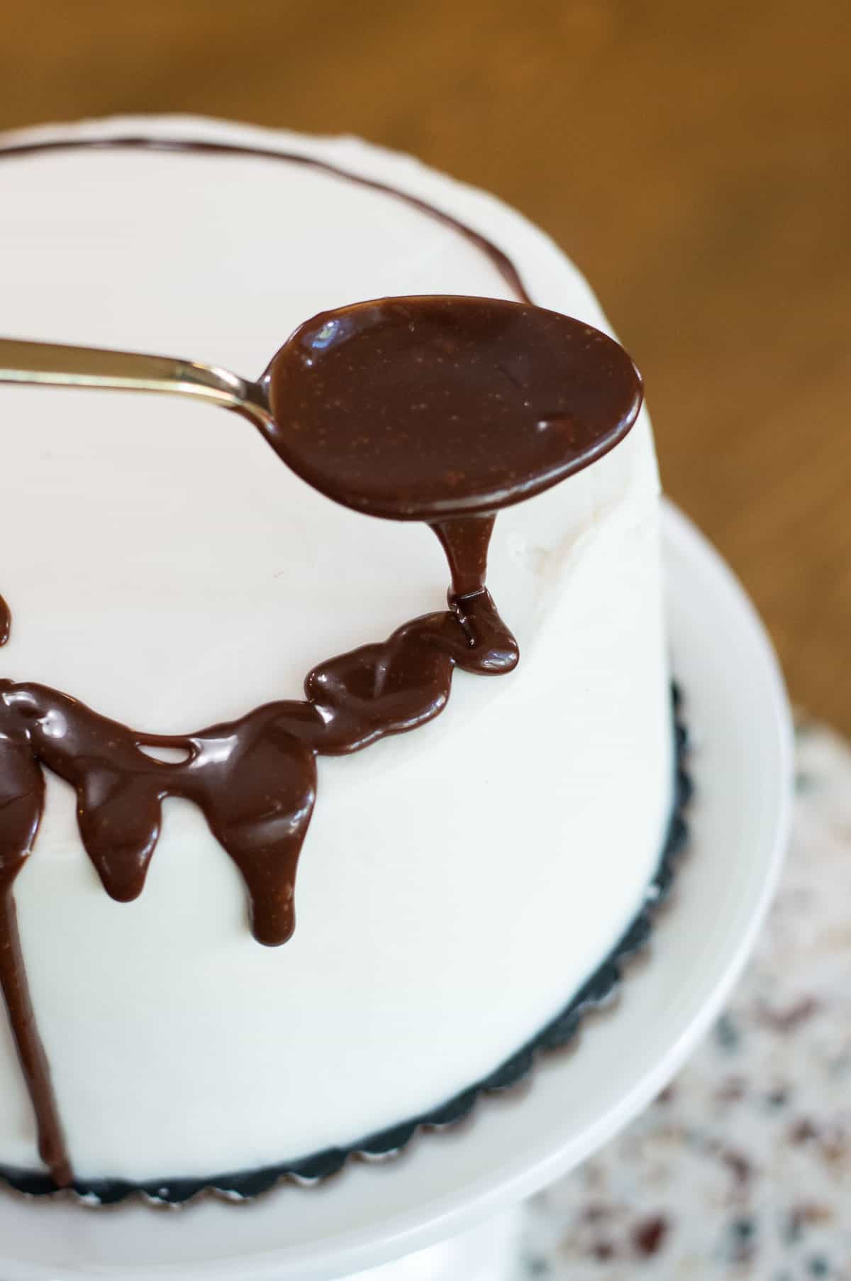 White frosted drip cake with chocolate ganache