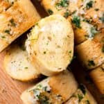 gluten free garlic bread on a tray with parmesan and parsley