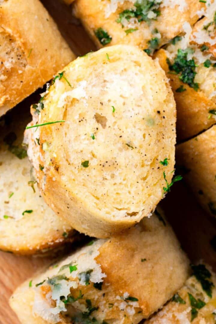 gluten free garlic bread on a tray with parmesan and parsley
