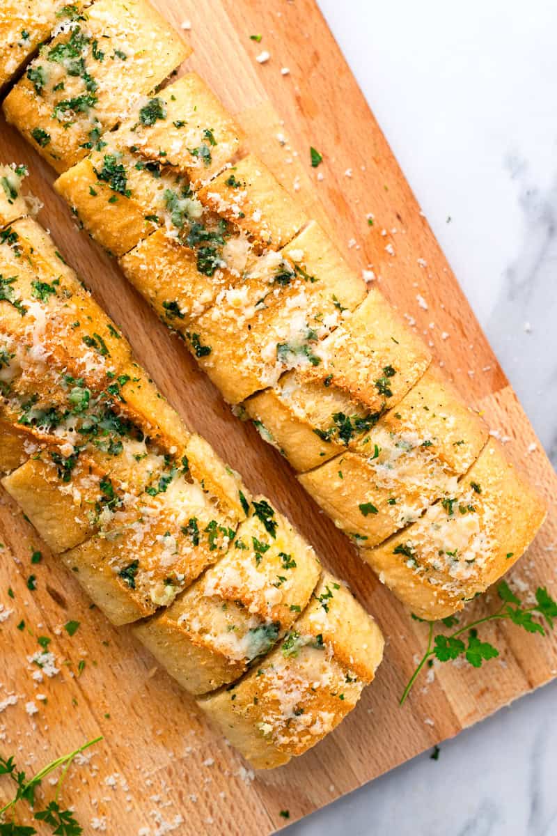 gluten free garlic bread sliced on a wood cutting board