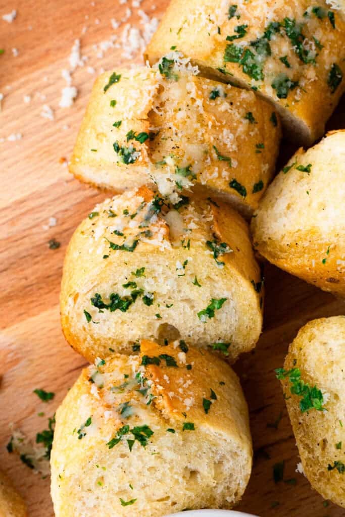 gluten free garlic bread sliced on a wood cutting board